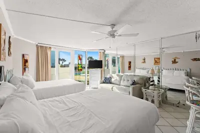 a white bedroom with two beds and a couch at Beach Front Ocean View Condo - Top of the Gulf 105 in Panama City Beach