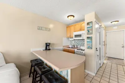 a kitchen with a counter top and a kitchen with a refrigerator at Beach Front Ocean Front Condo Top of the Gulf 516 in Panama City Beach