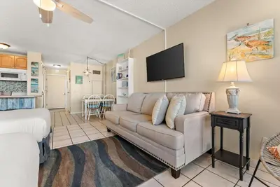 a living room with a couch and a tv at Beach Front Ocean Front Condo Top of the Gulf 516 in Panama City Beach