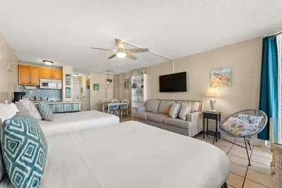 a living room with two beds and a couch at Beach Front Ocean Front Condo Top of the Gulf 516 in Panama City Beach