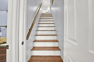 a staircase in a home with white walls and wooden floors at Largo Dream at Largo Mar in Panama City Beach