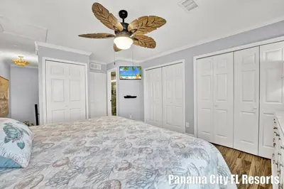 a bedroom with white doors and a ceiling fan at Largo Dream at Largo Mar in Panama City Beach