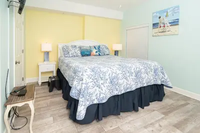 a bedroom with a bed with a blue and white bedspread at Sugar Sand at Ocean Reef in Panama City Beach