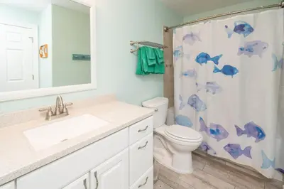 a bathroom with a toilet and a shower curtain at Sugar Sand at Ocean Reef in Panama City Beach