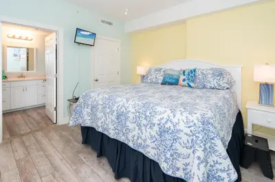 a bedroom with a bed with a blue and white bedspread at Sugar Sand at Ocean Reef in Panama City Beach