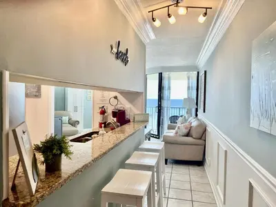 a kitchen and living room with a view of the ocean at Amazing View Beach Front King Bed in Panama City Beach