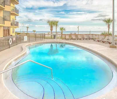 a large blue swimming pool in front of a building at Amazing View Beach Front King Bed in Panama City Beach