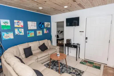 a living room with a white couch and a blue wall at Pet Friendly Cheerful home on Emerald Coast - by SharpCat in Panama City
