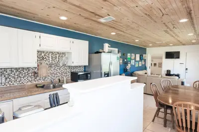 a kitchen with white cabinets and a wooden ceiling at Pet Friendly Cheerful home on Emerald Coast - by SharpCat in Panama City