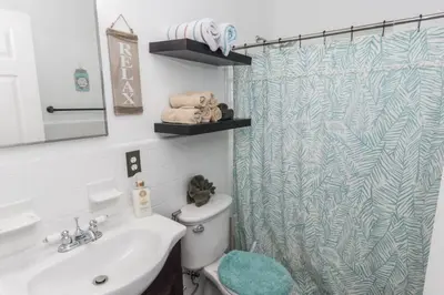 a bathroom with a shower curtain and a sink at Pet Friendly Cheerful home on Emerald Coast - by SharpCat in Panama City