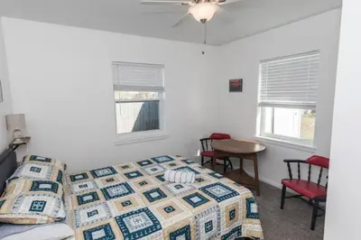 a bedroom with a bed and a table and chairs at Pet Friendly Cheerful home on Emerald Coast - by SharpCat in Panama City