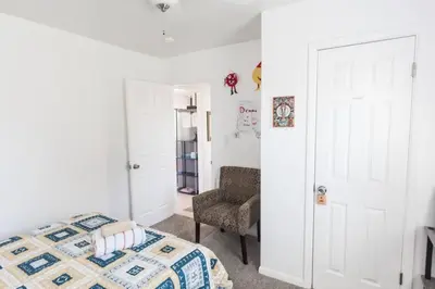 a bedroom with a bed and a chair at Pet Friendly Cheerful home on Emerald Coast - by SharpCat in Panama City