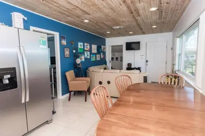 a kitchen with a table and a refrigerator at Pet Friendly Cheerful home on Emerald Coast - by SharpCat in Panama City