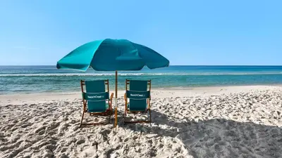two chairs under an umbrella on the beach at BeachCrest 1202 in Santa Rosa Beach