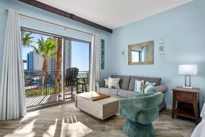 a living room with a couch and a large window at Origin 0633 - Studio King - Sunrise and Guilf Views in Panama City Beach