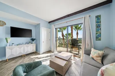 a living room with a couch and a tv at Origin 0633 - Studio King - Sunrise and Guilf Views in Panama City Beach