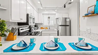 a kitchen with white cabinets and blue dishes on a counter at Portside Resort V4 in Panama City Beach