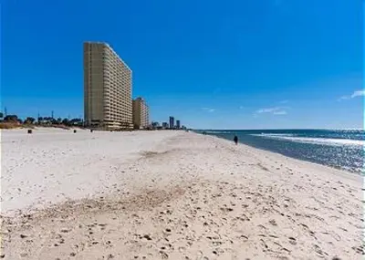 a sandy beach with a building in the background at Portside Resort V4 in Panama City Beach