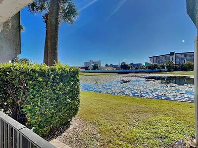 a body of water with a palm tree and a lake at Edgewater Villa #105 in Panama City Beach