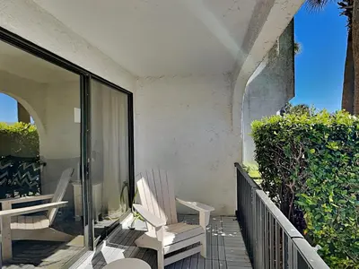 a pair of white chairs sitting on a balcony at Edgewater Villa #105 in Panama City Beach