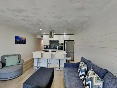 a living room with a couch and a kitchen at Edgewater Villa #105 in Panama City Beach