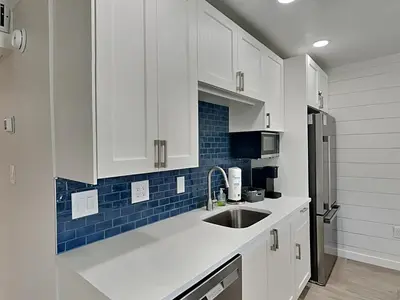 a kitchen with white cabinets and a sink at Edgewater Villa #105 in Panama City Beach