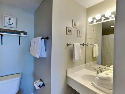 a bathroom with a sink and a toilet and a mirror at Shores of Panama #1707 in Panama City Beach