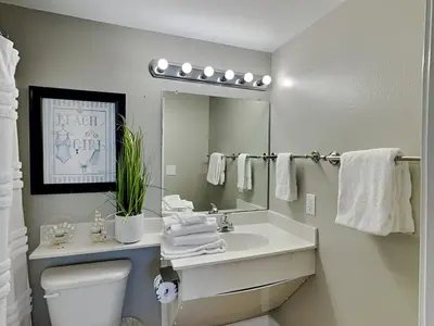 a bathroom with a sink and a toilet and a mirror at Shores of Panama #1707 in Panama City Beach