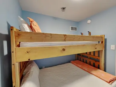 two bunk beds in a room with a blue wall at Shores of Panama #1707 in Panama City Beach