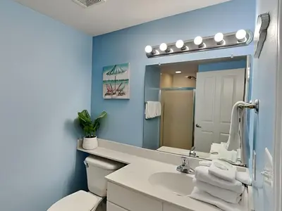 a bathroom with a sink and a toilet and a mirror at Shores of Panama #1707 in Panama City Beach