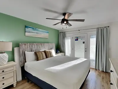 a bedroom with a bed with a ceiling fan at Stay Salty in Panama City Beach