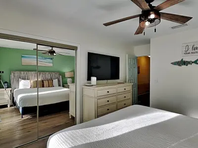 a bedroom with a bed and a flat screen tv at Stay Salty in Panama City Beach
