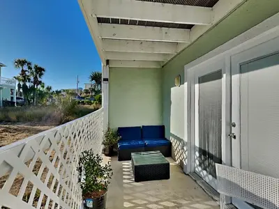 a porch with a blue couch on a balcony at Stay Salty in Panama City Beach