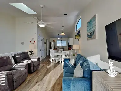 a living room with two couches and a dining room at Stay Salty in Panama City Beach