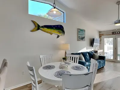 a dining room with a table and a blue couch at Stay Salty in Panama City Beach