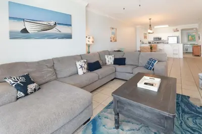 a living room with a couch and a table at The Sandy Pearl at Ocean Reef in Panama City Beach