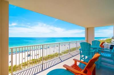 a balcony with two chairs and a view of the beach at The Sandy Pearl at Ocean Reef in Panama City Beach