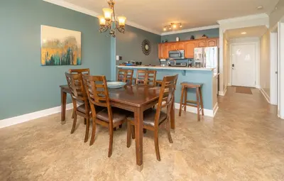 a kitchen and dining room with a wooden table and chairs at Blue Horizon at Ocean Reef in Panama City Beach