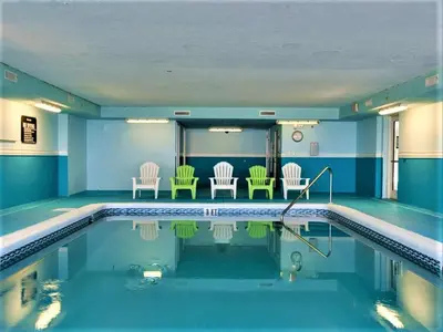 a swimming pool with chairs and chairs in a house at Forever Fun at Ocean Reef in Panama City Beach