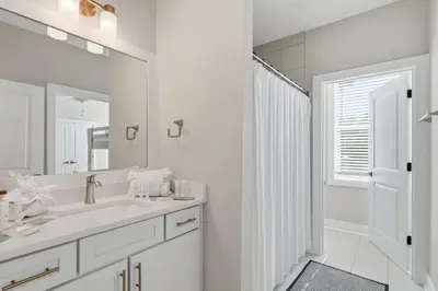 a white bathroom with a sink and a mirror at Family Coastal Escape in Inlet Beach