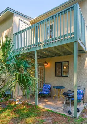 a patio with a deck and a table and chairs at Sea This Way in Panama City Beach