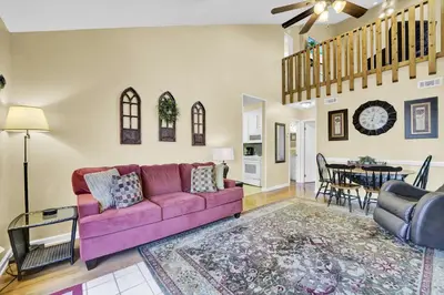 a living room with a purple couch and a dining room at The Shell House in Panama City Beach