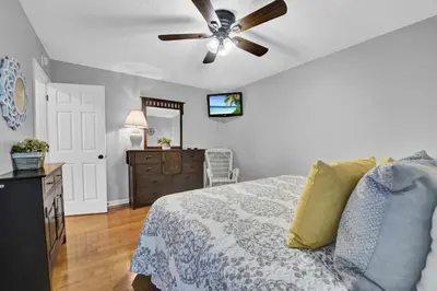 a bedroom with a bed and a ceiling fan at The Shell House in Panama City Beach