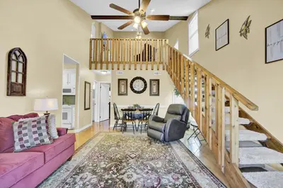a living room with a pink couch and a dining room at The Shell House in Panama City Beach