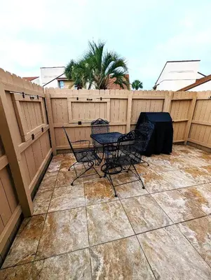 a patio with a table and chairs on a fence at The Shell House in Panama City Beach