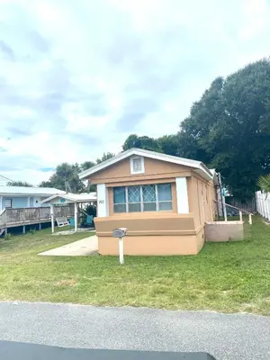 a small house sitting on top of a yard at The Cozy Jamozy in Panama City Beach