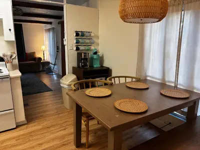 a dining room table with four chairs and a kitchen at The Cozy Jamozy in Panama City Beach