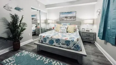 a bedroom with a bed and a potted plant in it at Cheap Getaway, Ocean View, PCB in Panama City Beach