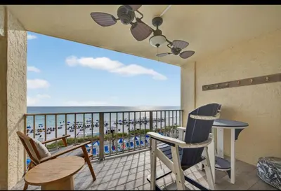 a balcony with chairs and a table and a view of the ocean at Our Sea Side in Panama City Beach