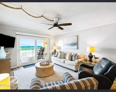 a living room with a couch and a ceiling fan at Our Sea Side in Panama City Beach